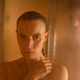 A man watches a woman in the shower.